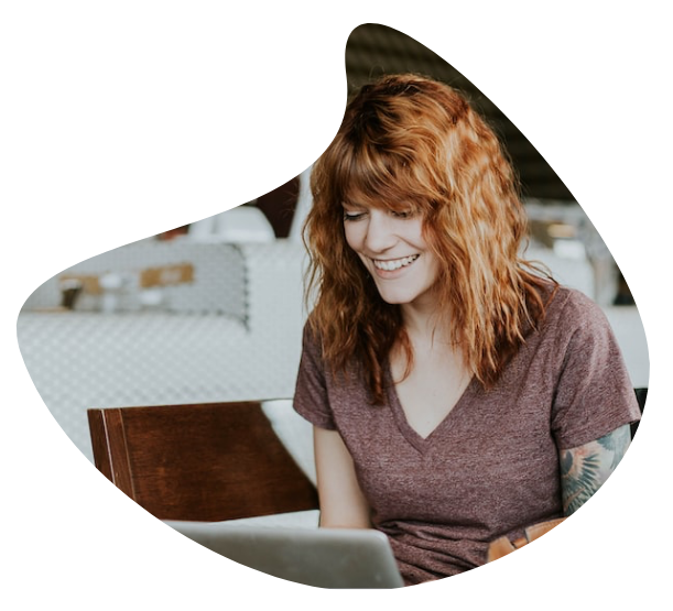 A woman smiling at her laptop